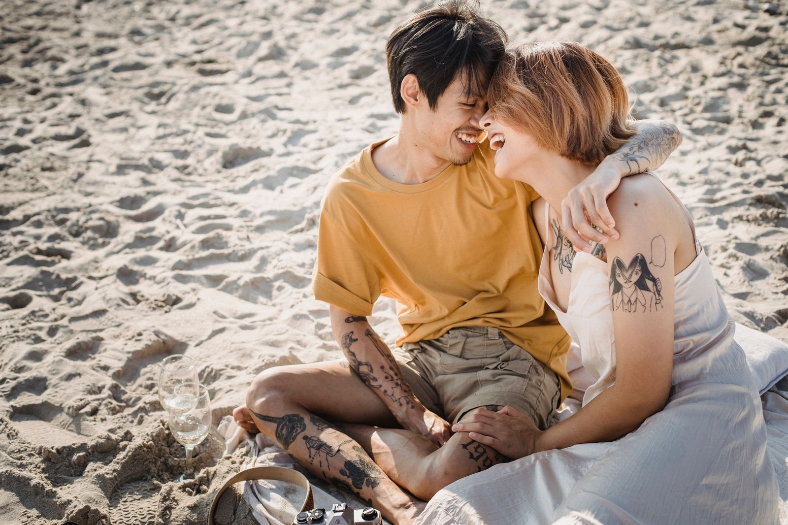 Couple laughing together on a sandy beach