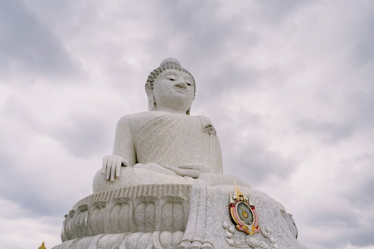 A large white Buddha statue against the sky