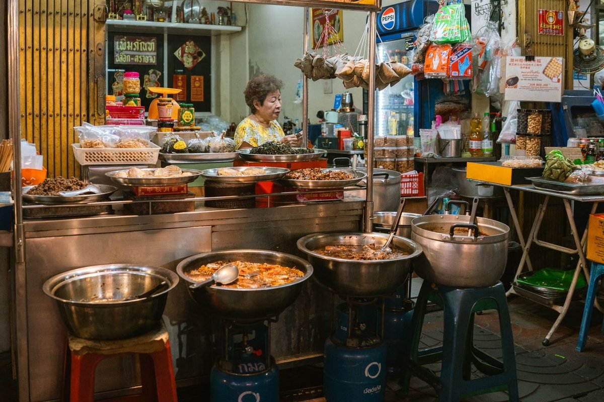 A street food stall with pots of cooked dishes