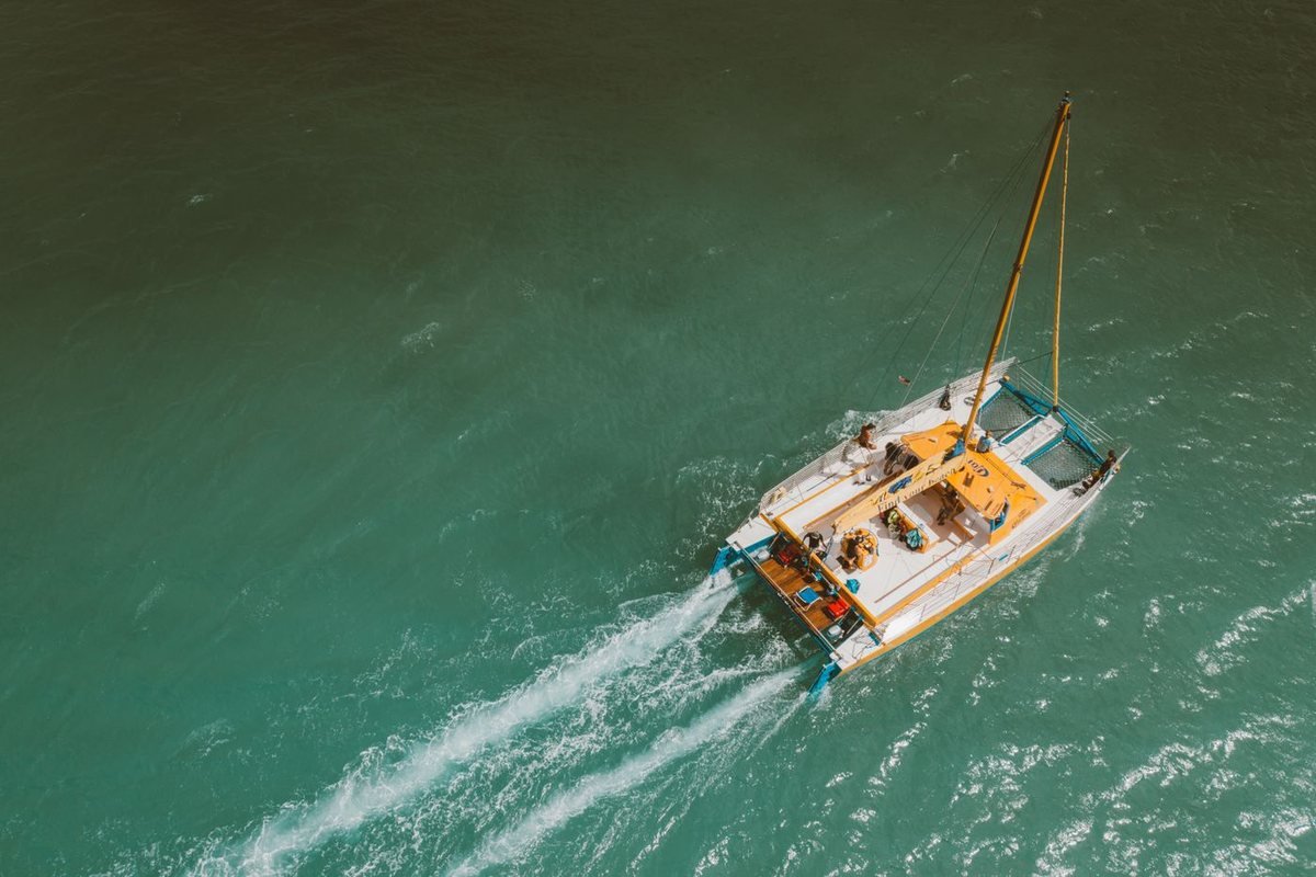 A sailing boat cruising on green sea water